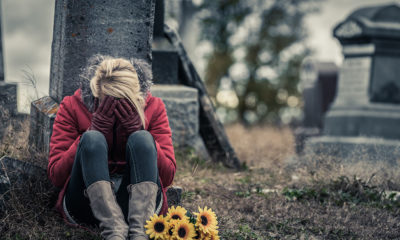 Woman-sitting-in-by-grave-400x240.jpg