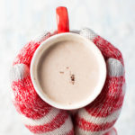 Hands offering hot cocoa