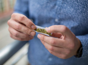 young man with tube of marijuana