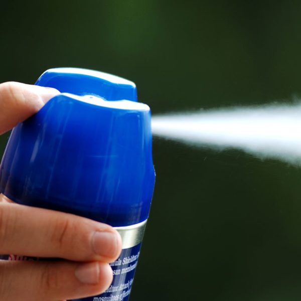 hand spraying from aerosol can