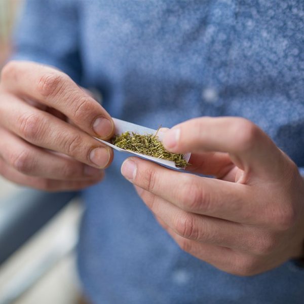 young man with tube of marijuana